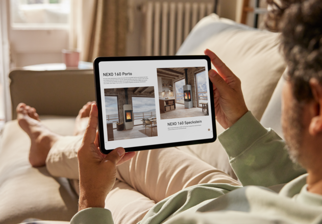 Sitzender Mann auf dem Sofa blättert online auf dem Ipad im Attika Katalog