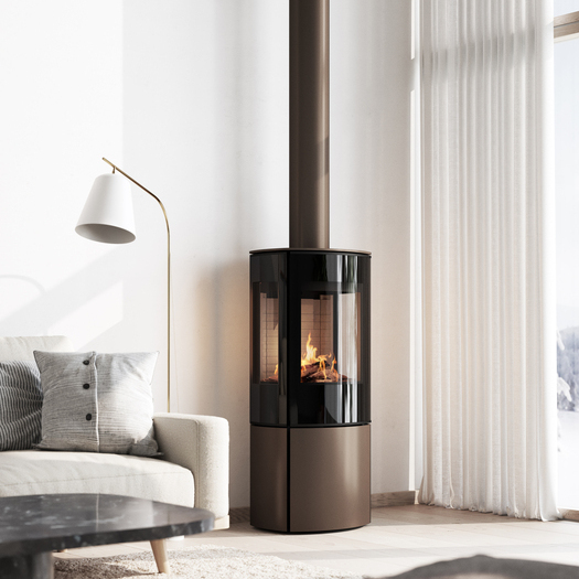 Poêle à gaz CARO 110 en mocca avec porte de foyer plein verre et vitre latérale dans un salon confortable