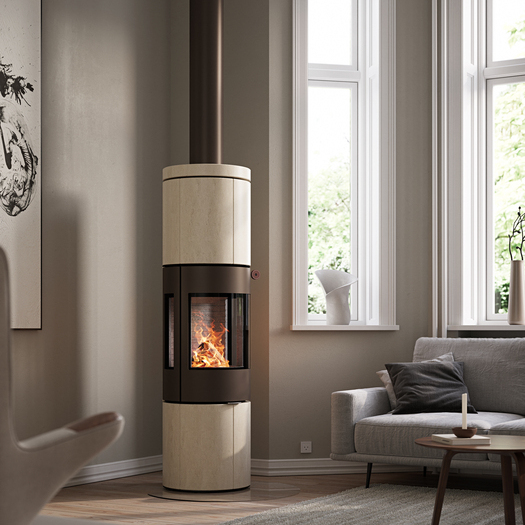 Poêle à bois JUNO 166 L avec revêtement en pierre naturelle Porto et vitres latérales dans un salon moderne dans les tons de terre