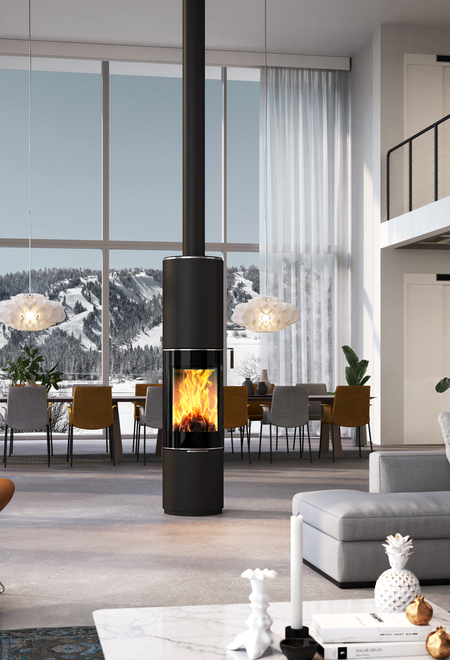 Poêle à bois PILAR en noir avec porte de foyer plein verre comme poêle rond pivotant au milieu d'une immense pièce à vivre