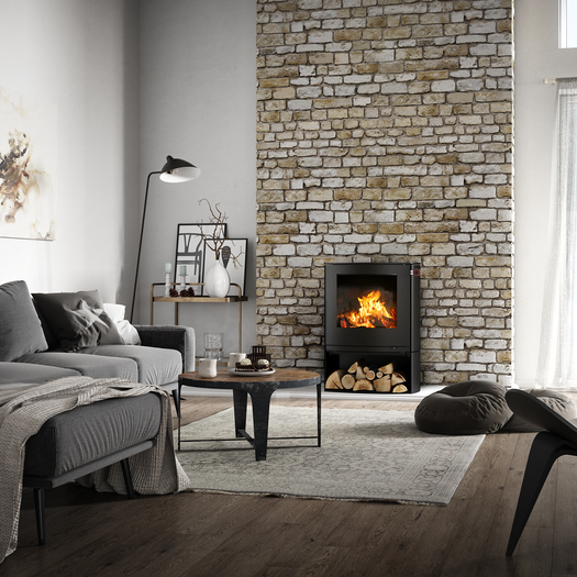 Poêle à bois Q-TEE 2 C en noir avec compartiment à bois dans sa forme légèrement ovale comme foyer dans une maison de campagne rustique