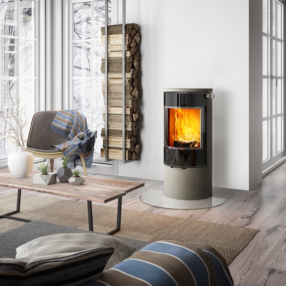 Poêle à bois VIVA 100 L en nickel avec porte de foyer plein verre dans une élégante pièce à vivre de style campagnard